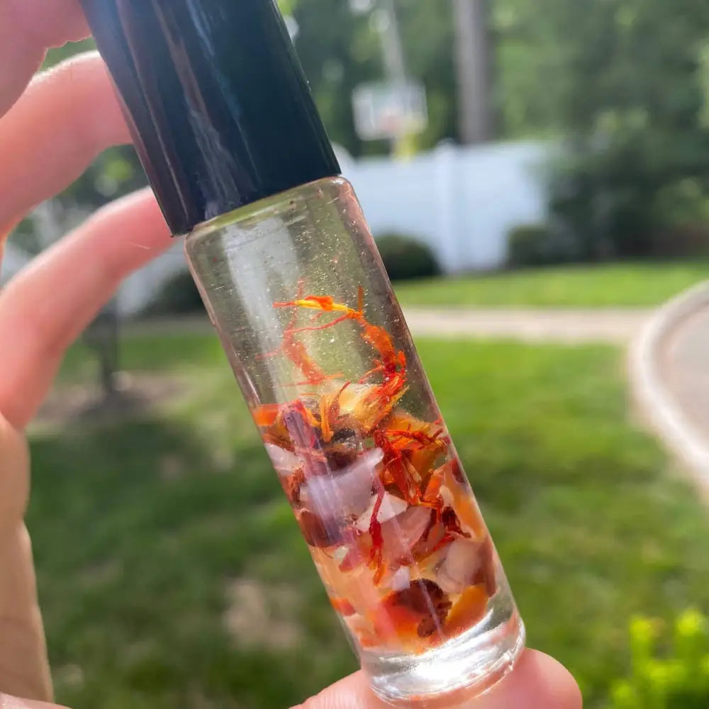 Carnelian Crystal Perfume Roller 10ml in clear glass bottle with amber liquid and dried orange flowers
