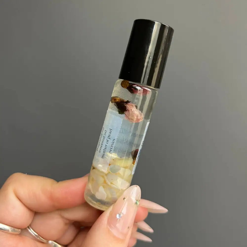 Clear glass rollerball pen with floral accents and silver cap for 10ml travel perfume