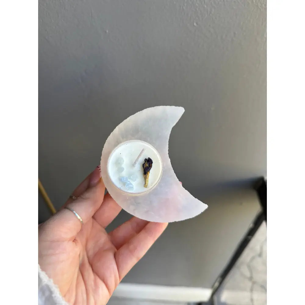 White selenite crescent moon candle holder with black wax drips for calming energy
