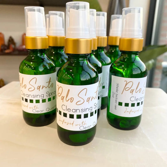 Palo Santo cleansing spray with clear quartz in green bottle and gold cap