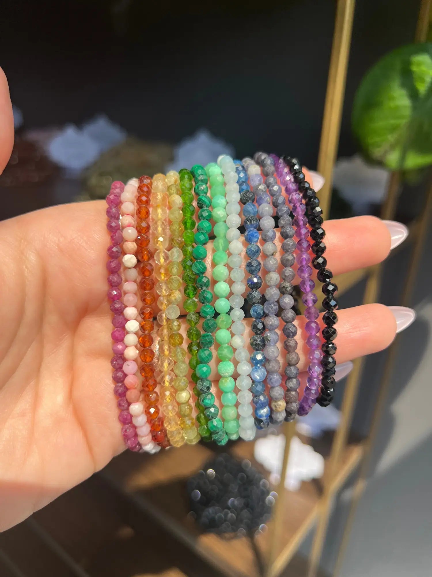 Vibrant multi-colored faceted crystal and gemstone beaded bracelets in hand