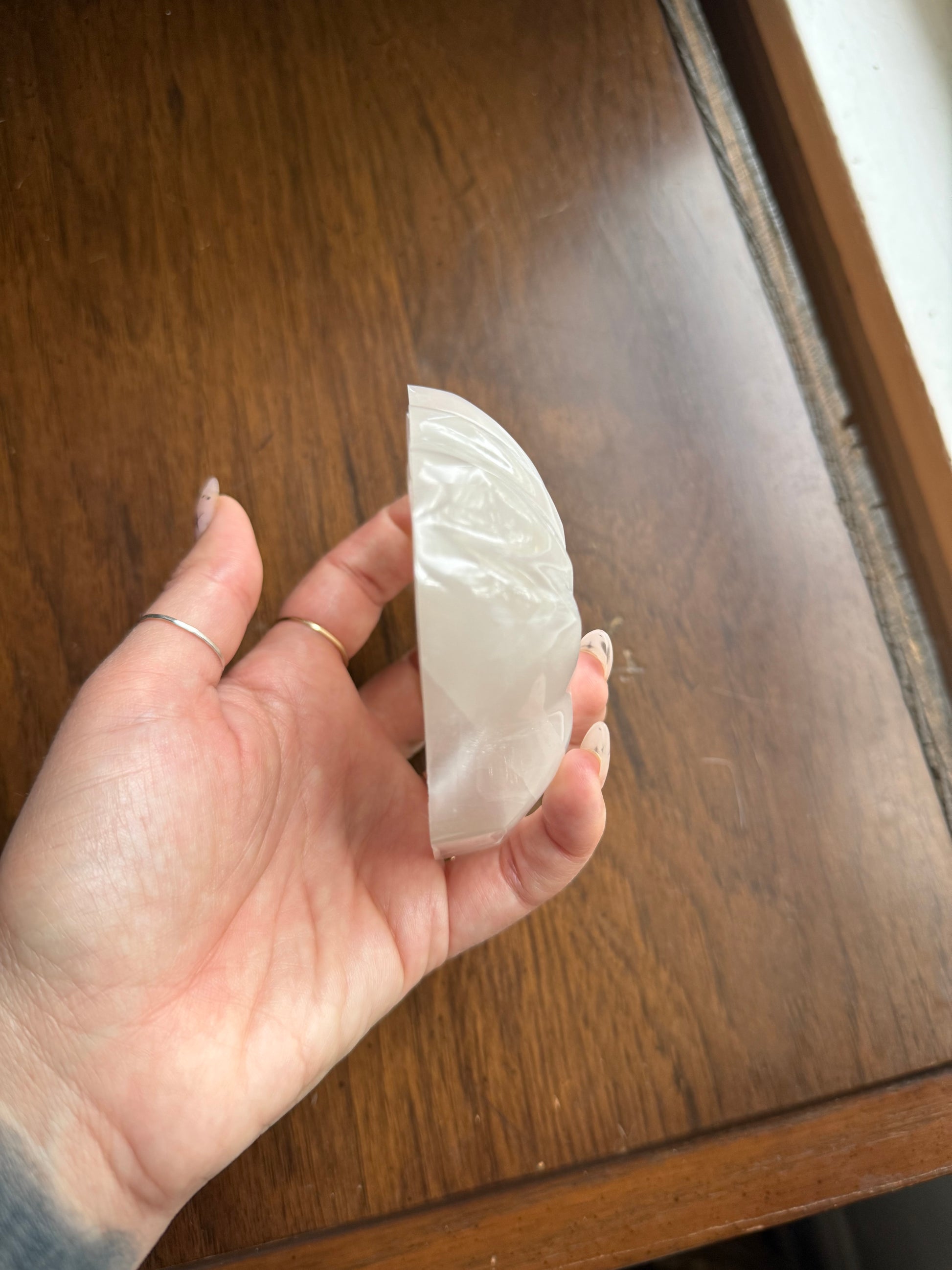 Selenite shell bowl side profile resting on a wood surface
