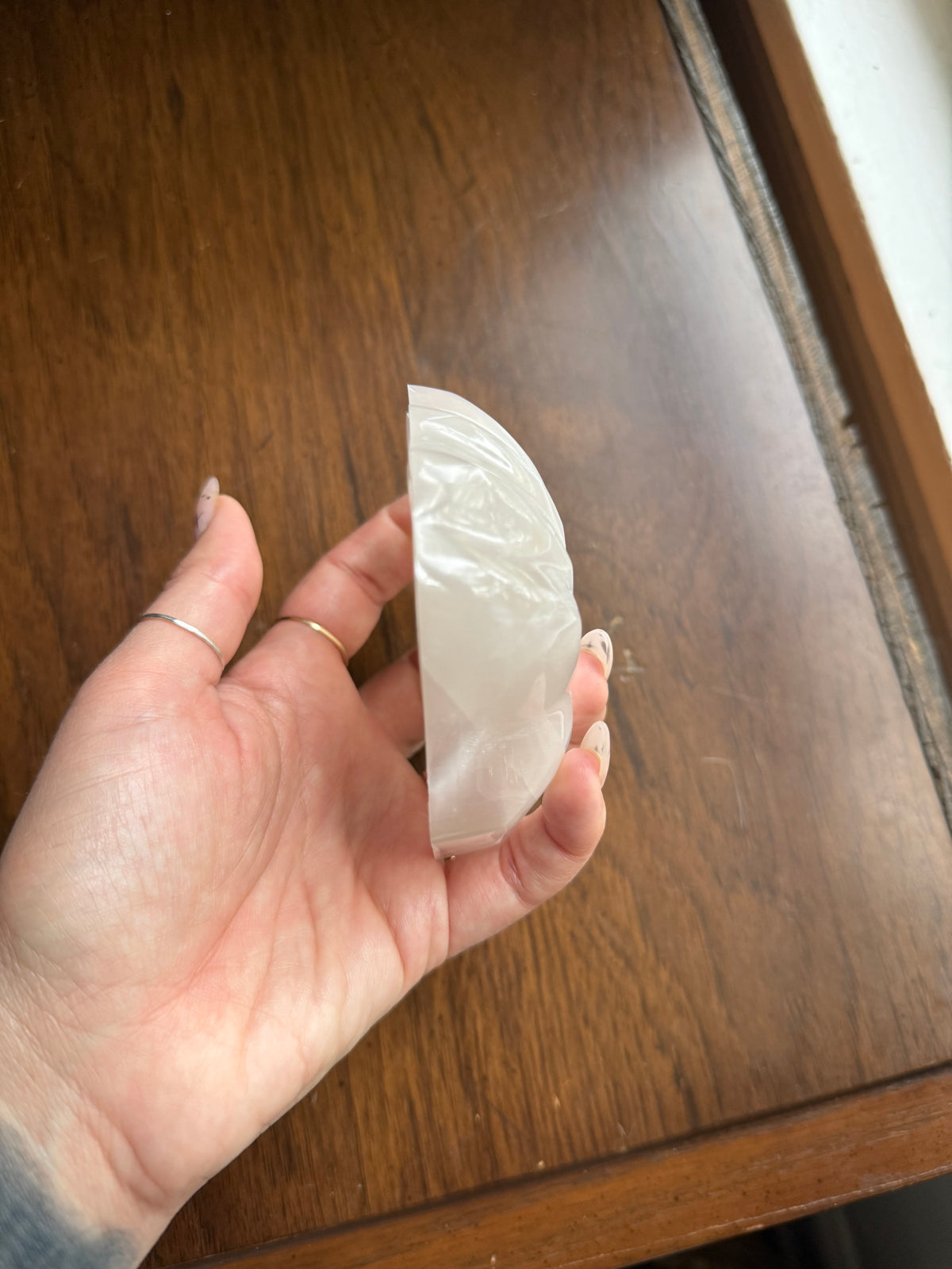 Selenite shell bowl side profile resting on a wood surface
