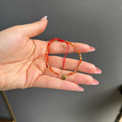 Orange beaded adjustable crystal gemstone bracelet with gold clasp and heart charm