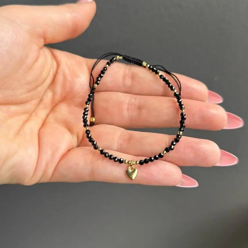 Handmade black beaded adjustable bracelet with gold accents and heart charm
