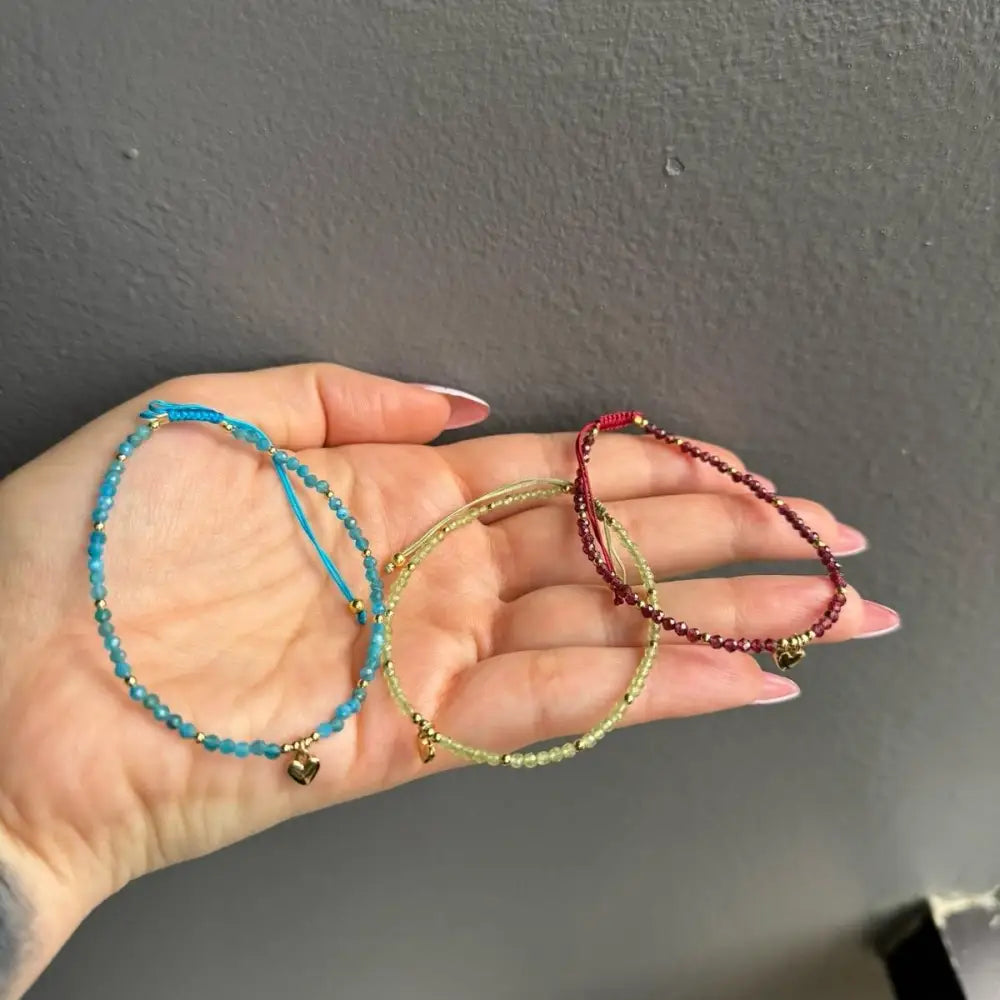 Blue beaded heart charm bracelet with gold accents and adjustable crystal gemstones