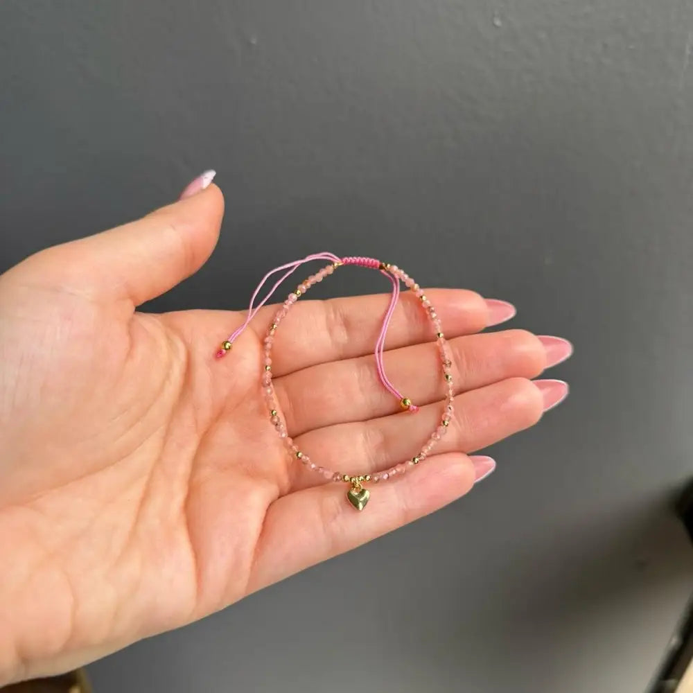 Rose gold beaded friendship bracelet with pink string and heart charm