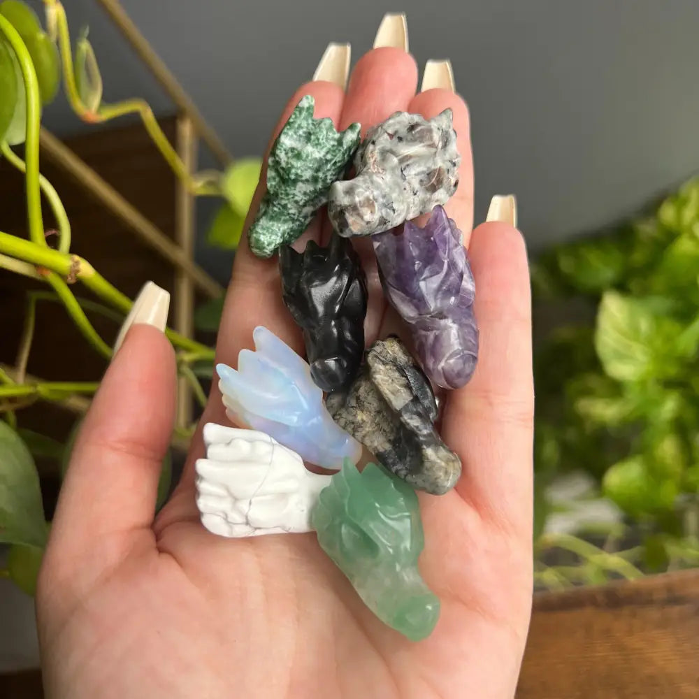 Hand holding multi-colored crystal animal figurines for peace and calm
