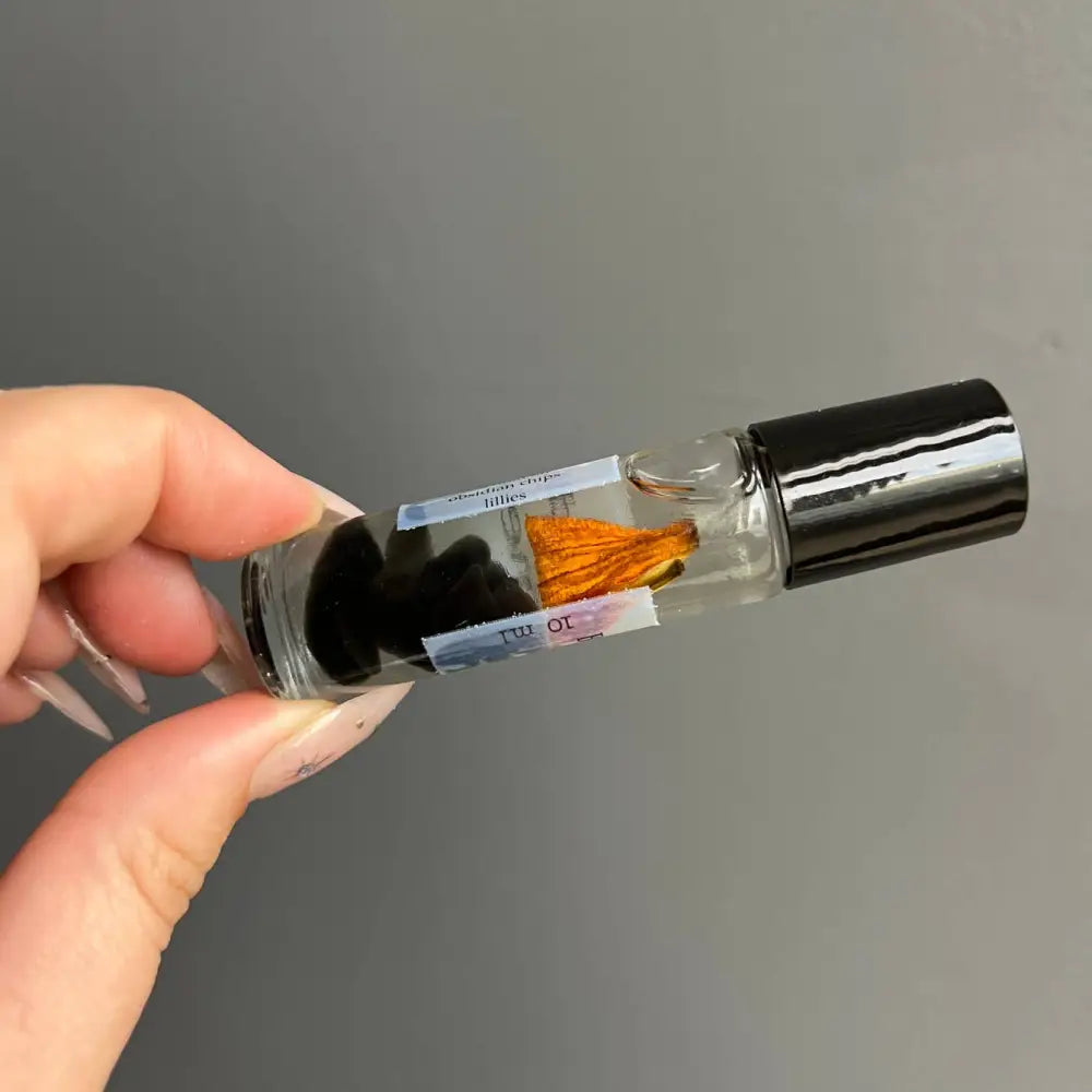 Black Obsidian crystal perfume rollerball with coconut oil, clear glass, black cap, orange tassel