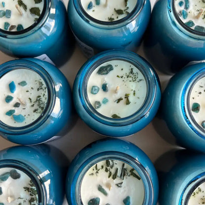 Blue glass soy wax candle jar with white wax and green specks
