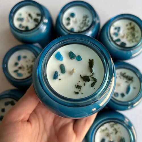 Blue glass soy wax candle in reusable jar with white wax and stones