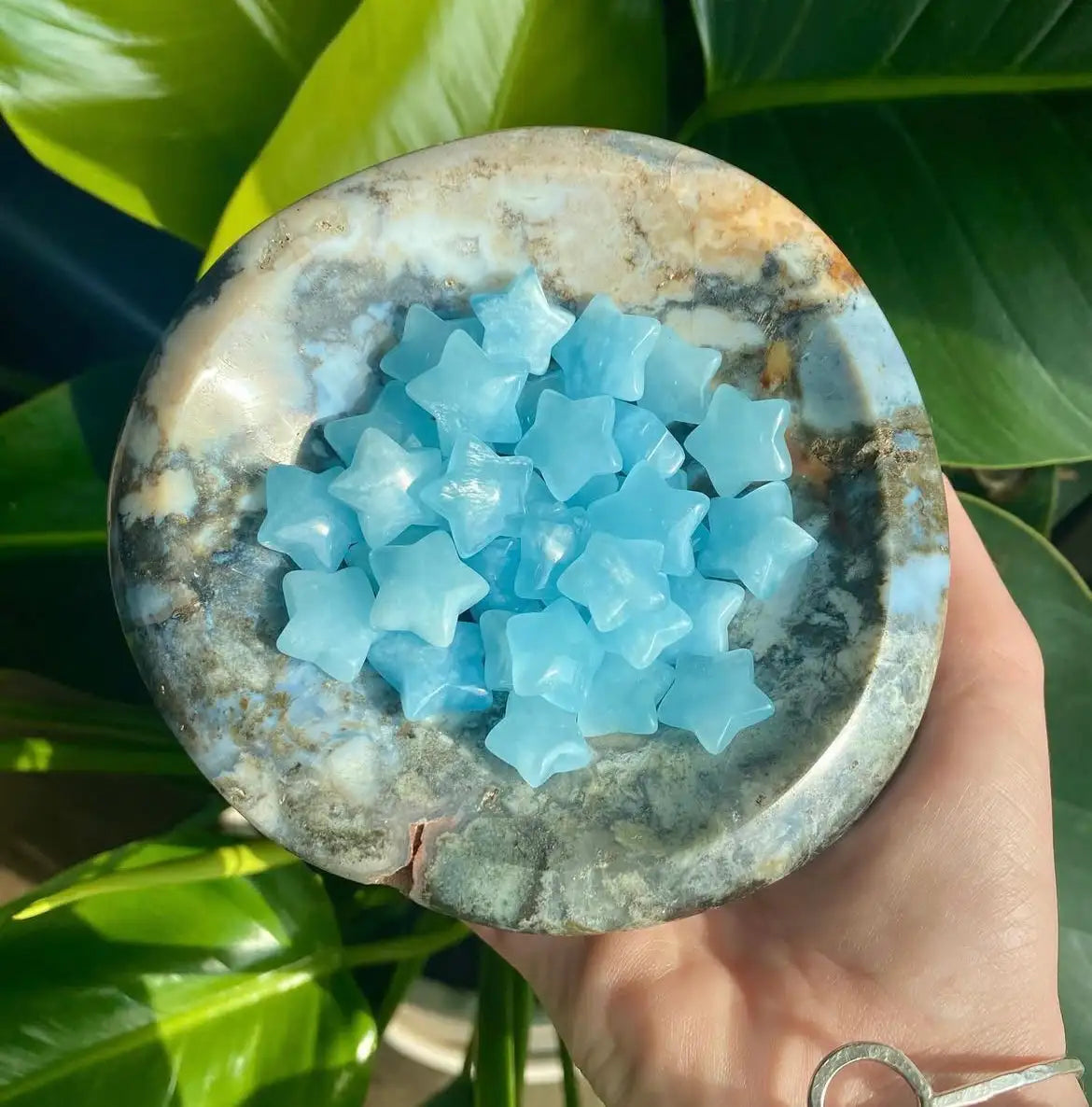 Blue star-shaped soap bars in a natural stone bowl.