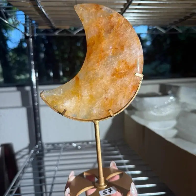 Gold crescent moon figurine with fire quartz stone texture on brass stand