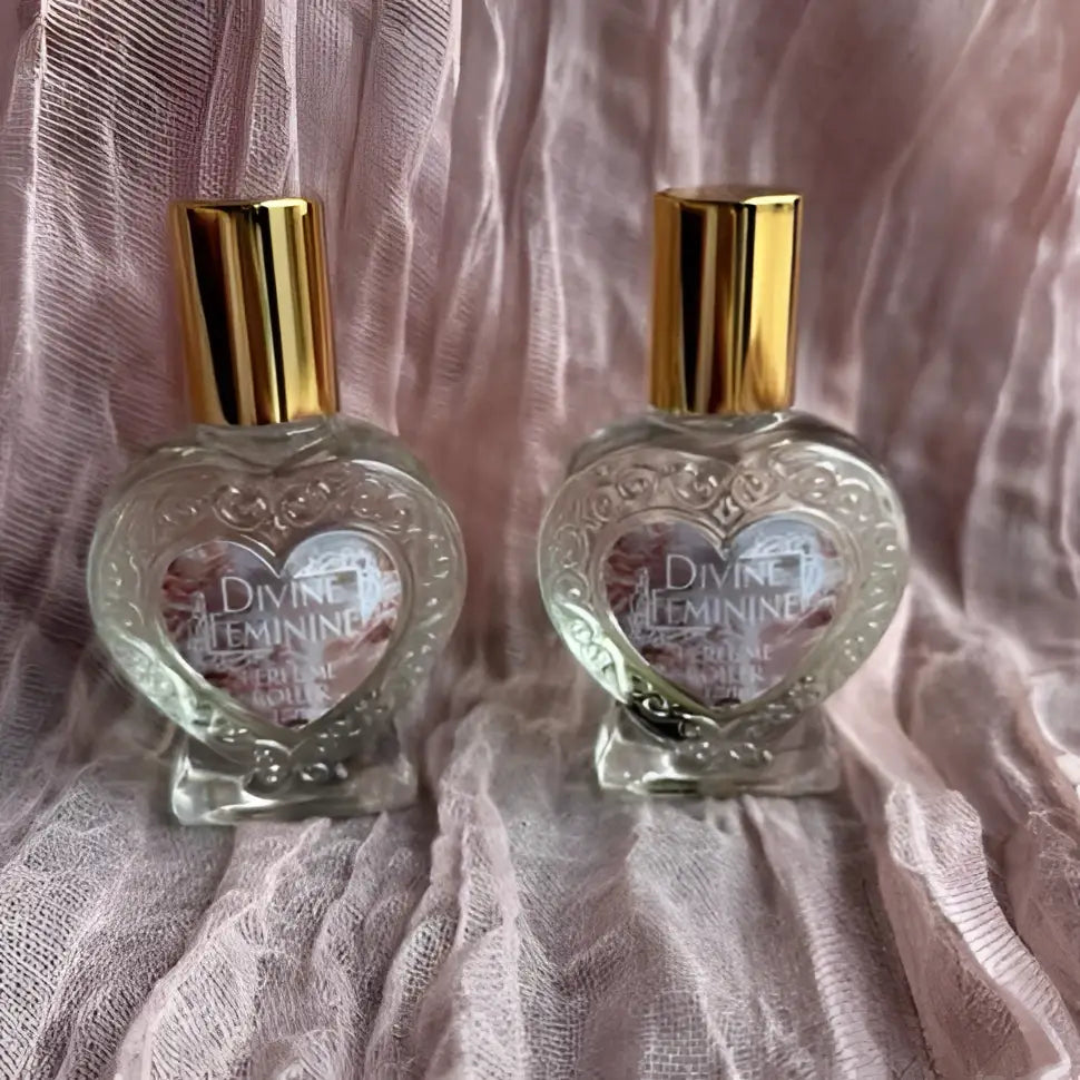 Heart-shaped crystal rollerball perfume with gold cap and floral botanicals