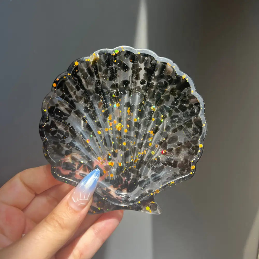 Clear scallop shell trinket dish with black gold glitter and crystals