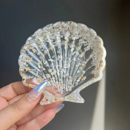 Clear scallop shell trinket dish with glitter and embedded shells in resin