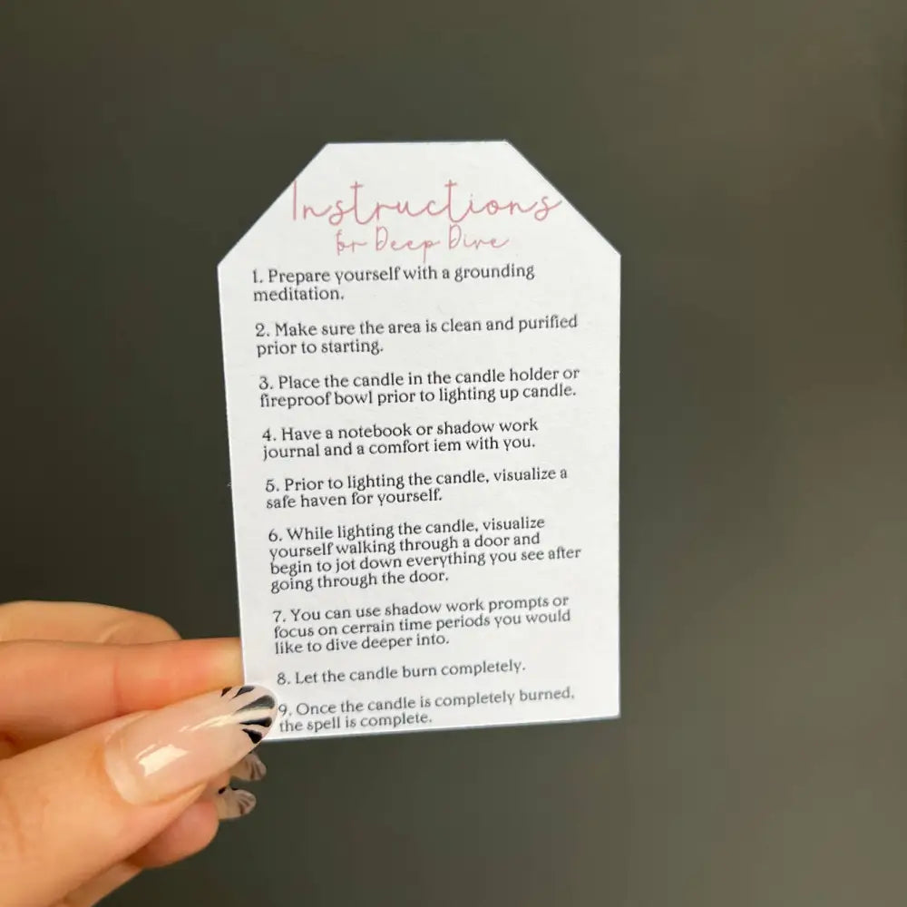 Hand holding white tag with black text and pink accents for Shadow Work Ritual Candles
