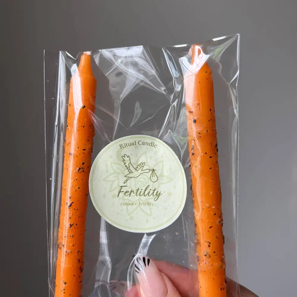 Orange speckled taper candles in clear pack with fertility label