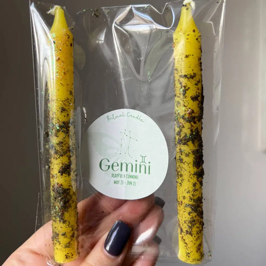 Yellow speckled Gemini Zodiac ritual candle set of two in clear plastic packaging