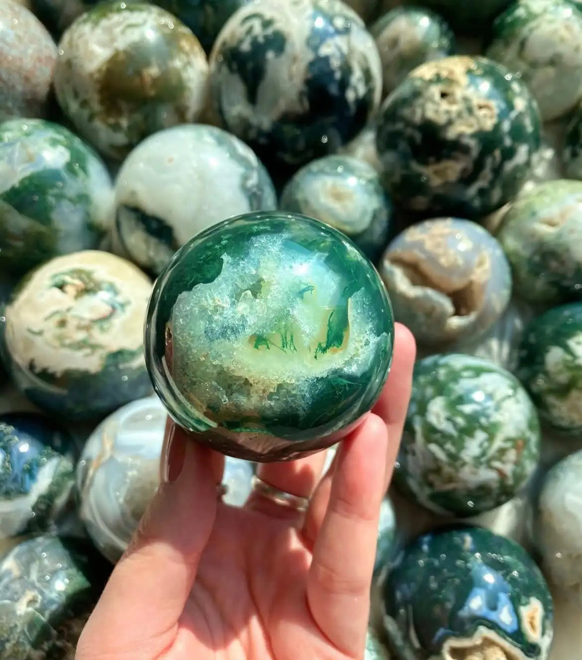 Green marble sphere with intricate veining and polished surface.