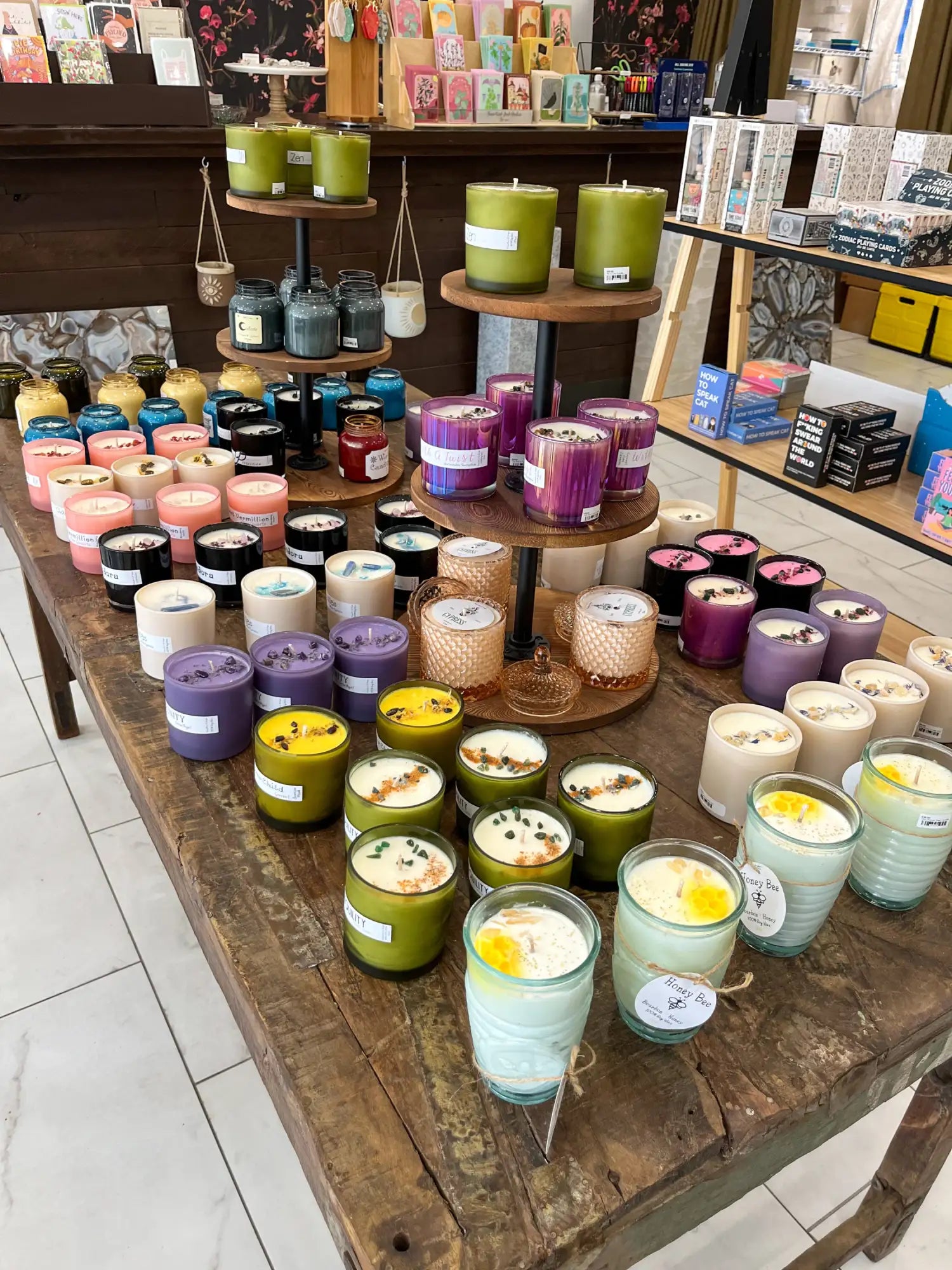 Green soy wax candles with wooden wicks, displayed on a rustic wood table.