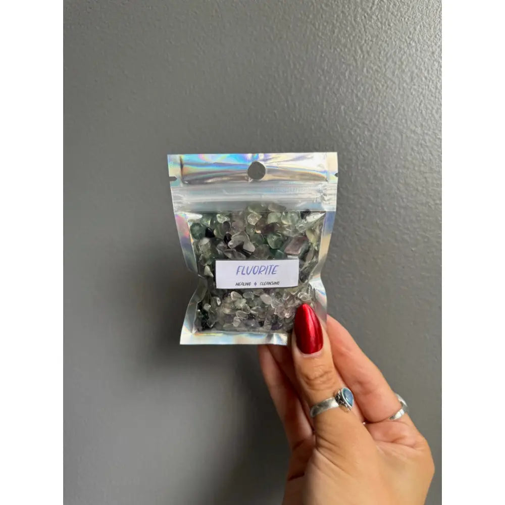 Clear fluorite chip stones in plastic bag with silver ring and red polish