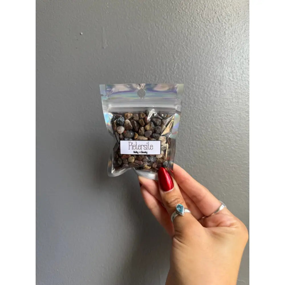 Clear plastic bag of parsley seeds with red nail polish and silver rings