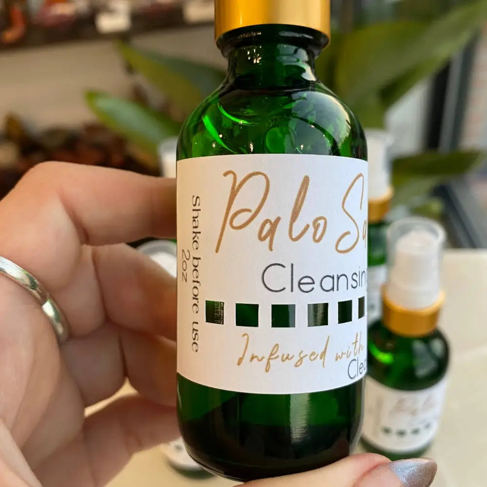 Green Palo Santo Cleansing Spray bottle with gold cap and clove oil