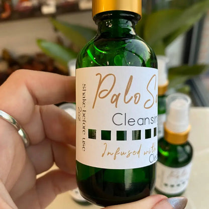 Green Palo Santo Cleansing Spray bottle with gold cap and clove oil