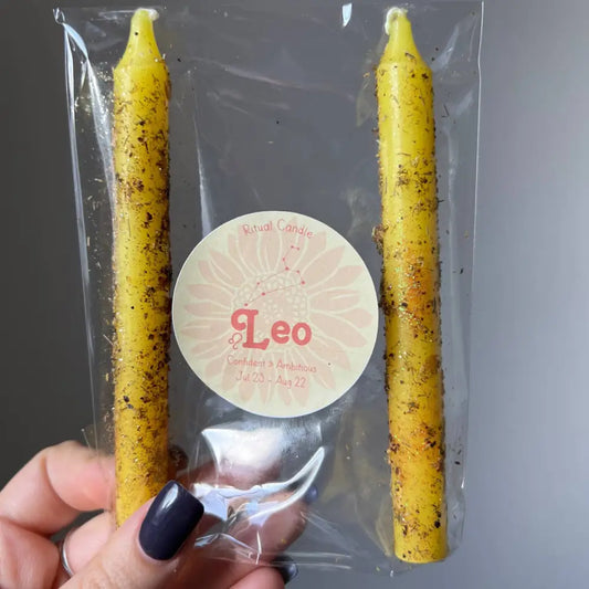 Leo Zodiac ritual candle set with yellow beeswax candles and black speckles in clear plastic