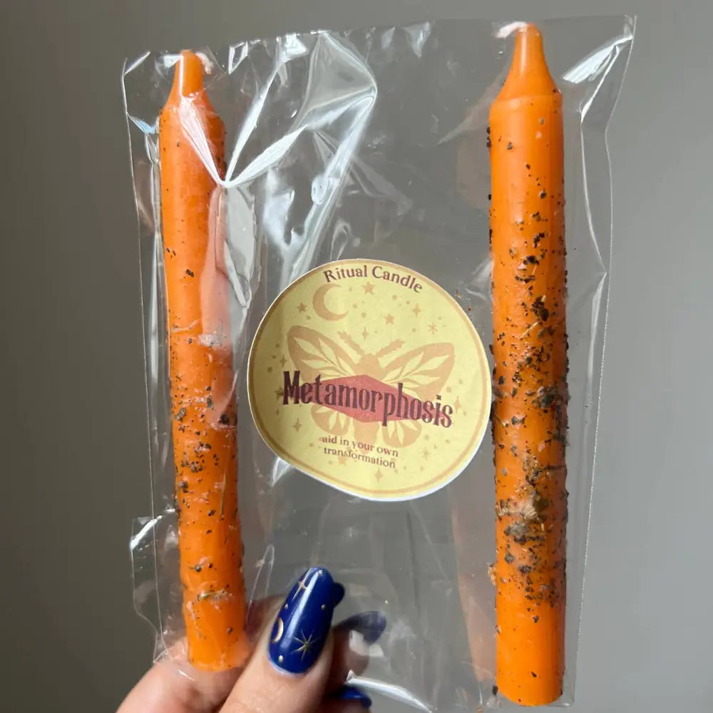 Orange Metamorphosis ritual candle with black speckles in clear plastic packaging