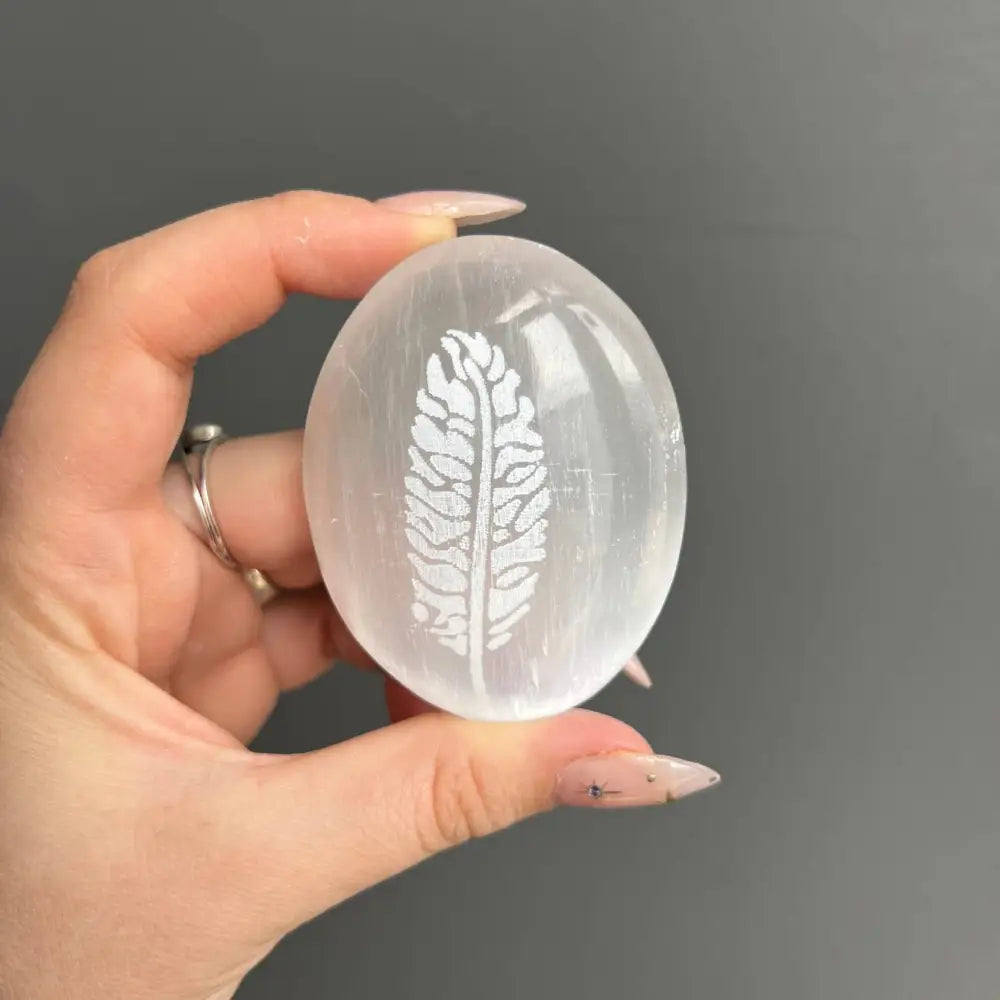 Etched selenite palm stone with feather design carved from natural Moroccan selenite