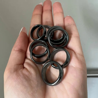 Matte black metal grommets with silver accents on natural hematite stone ring