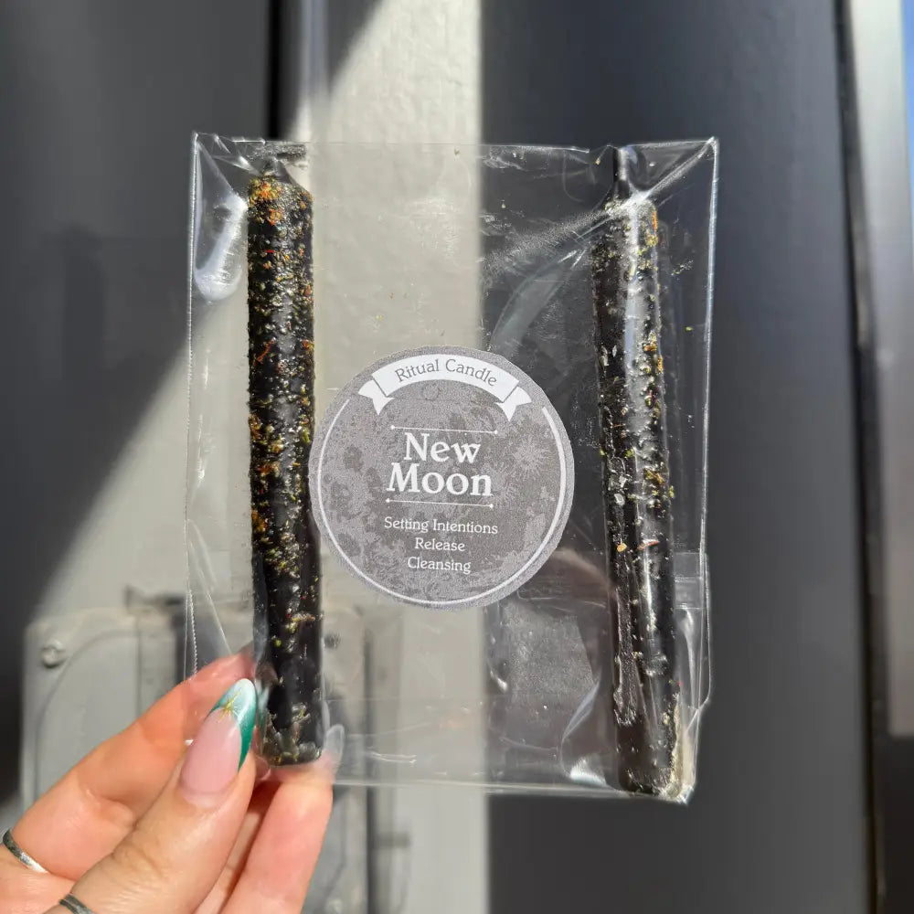 Black and green speckled New Moon ritual candles in clear packaging
