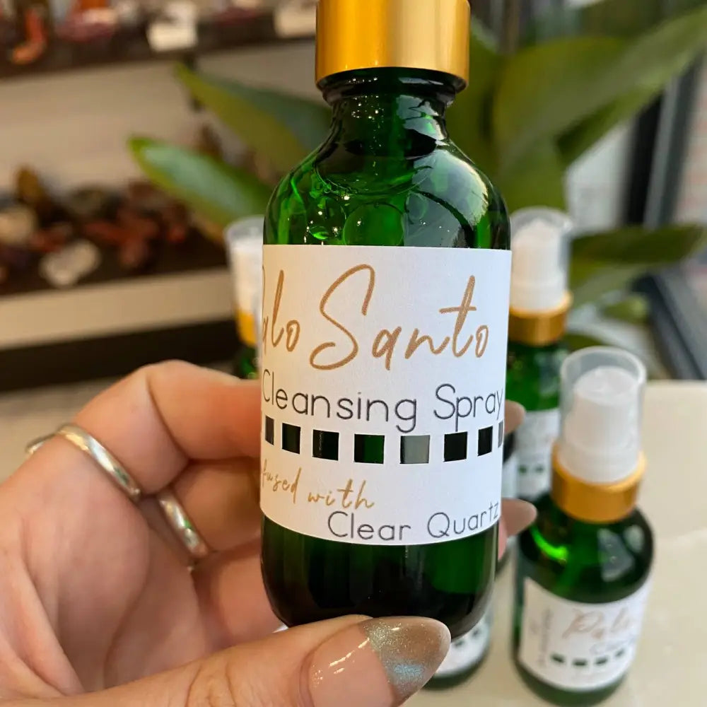 2oz Palo Santo cleansing spray in green glass bottle with gold cap and clear quartz