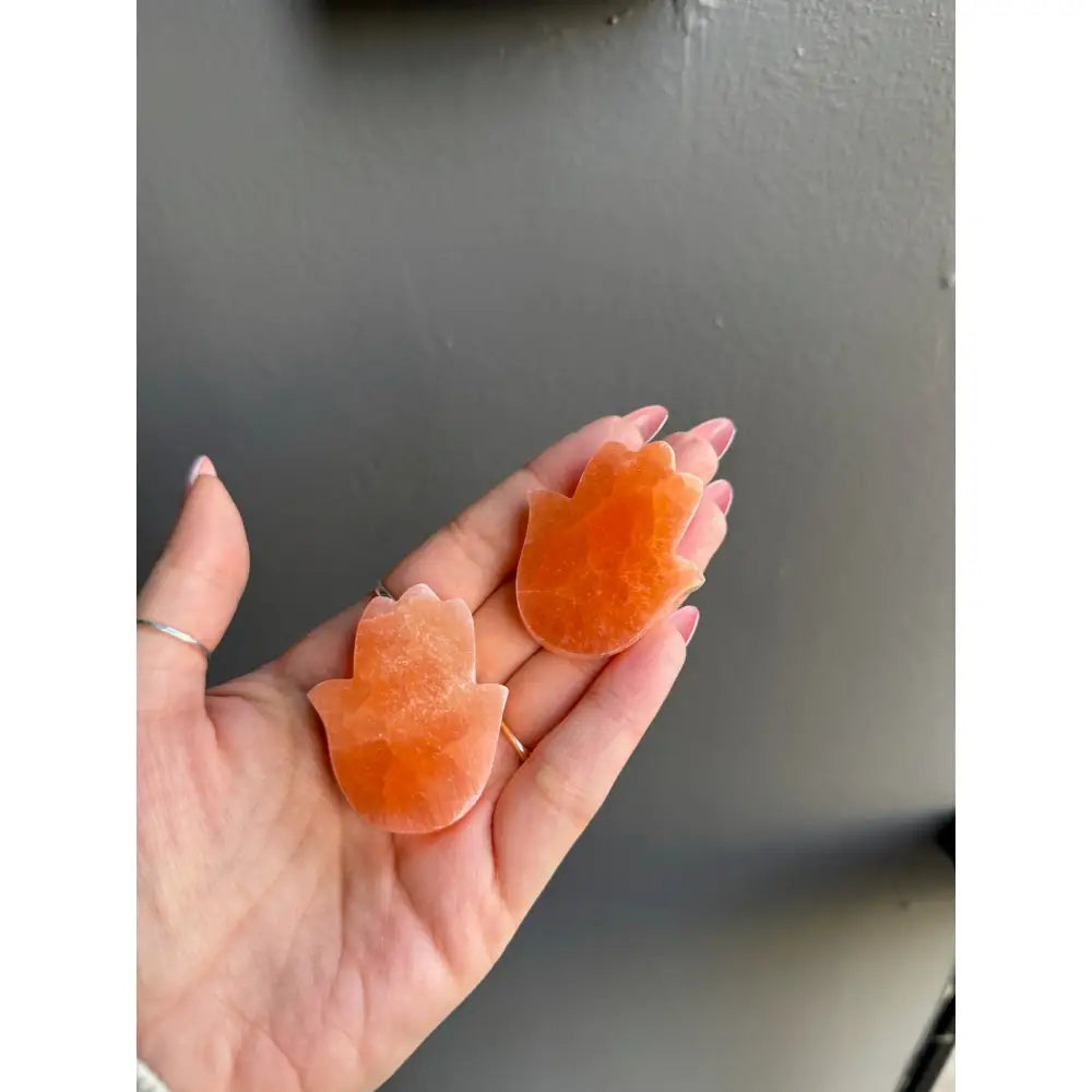 Orange star-shaped soap bars on Peach Selenite Hamsa Hand crystal