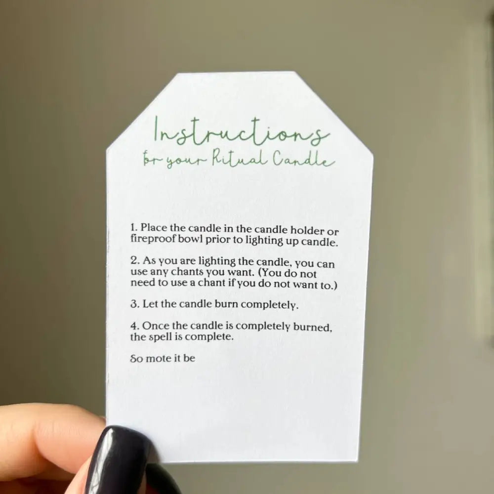 White paper tag with green ritual instructions on handmade 5 inch Nashville candle