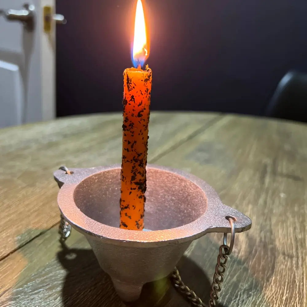 Terracotta Return to Sender ritual candle holder with lit orange candle and chains