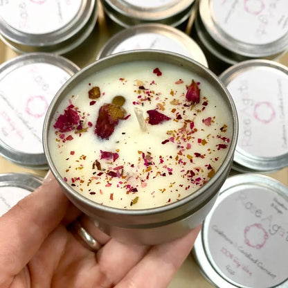 Hand holding cream soy Rose Agate Tin Candle with dried roses and leaves, 4oz