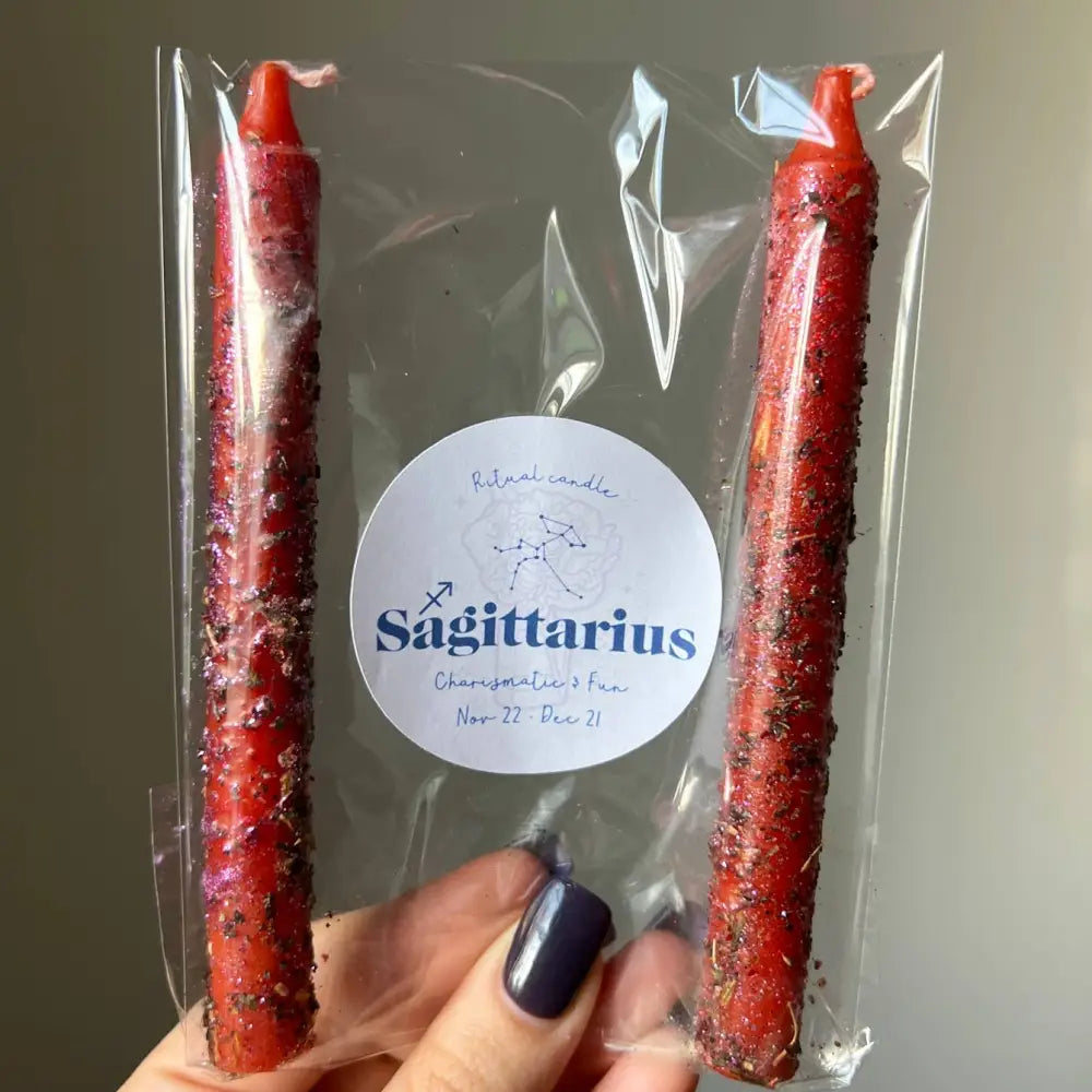 Red glittery Sagittarius zodiac ritual candle with herbs, oils, clear wrapper