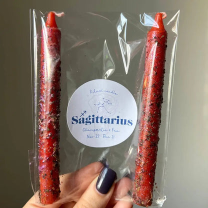 Red glittery Sagittarius zodiac ritual candle with herbs, oils, clear wrapper