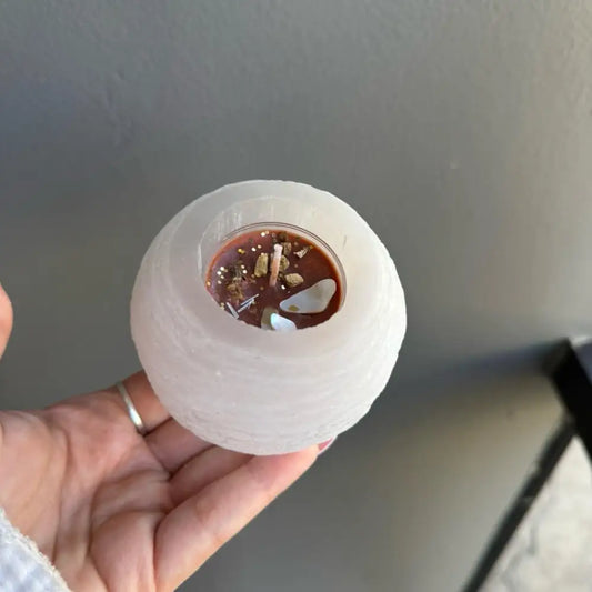 Selenite candle holder with frosted glass, brown wax, and decorative elements for calming energy