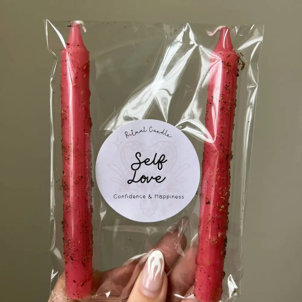 Red speckled taper candles in clear pack with Self Love label for confidence ritual