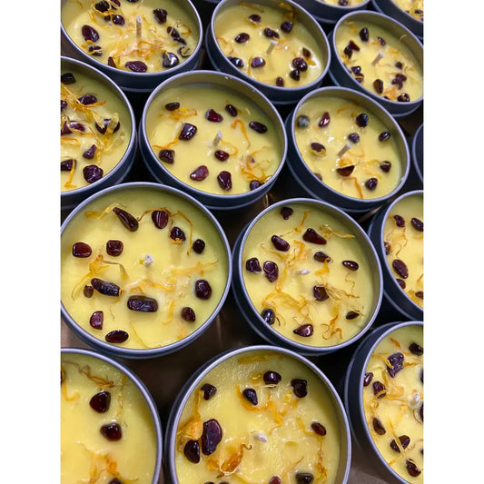 Artisanal yellow candle with orange zest and raisins in Garnet and Calendula Jasmine Musk 4oz tin