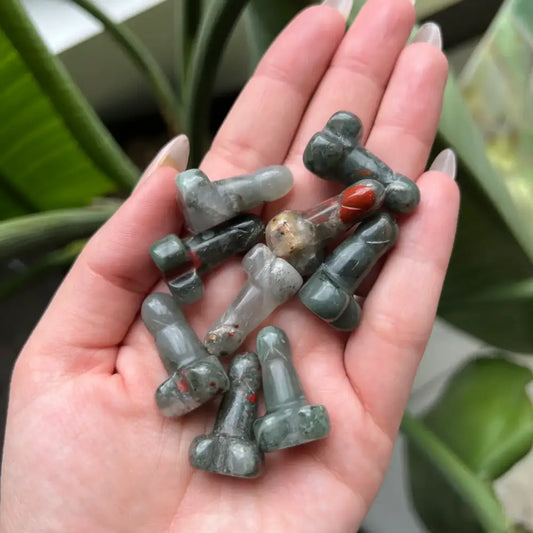 Green and white dog-shaped glass beads in 1-inch natural stone crystal phallus carving