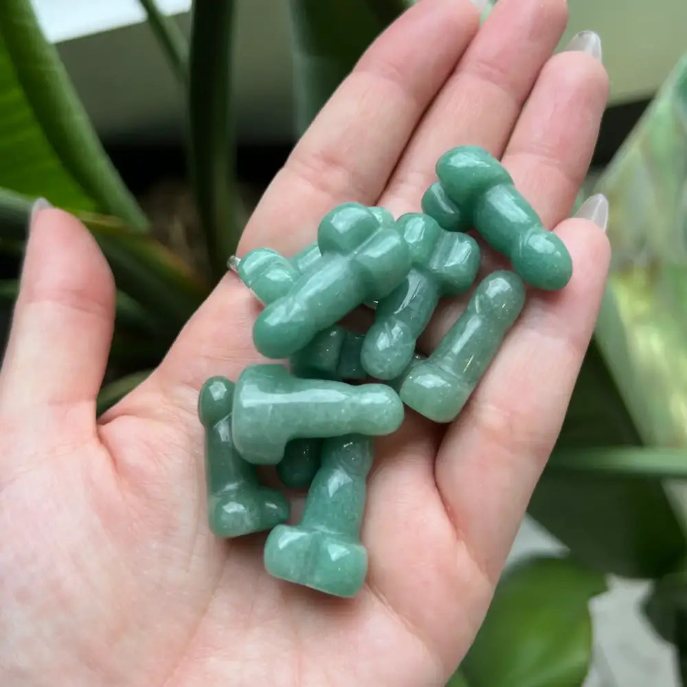 Hand holding green gummy bear on 1 inch crystal phallus carving