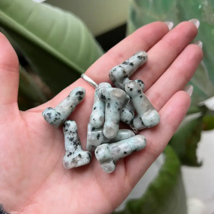 1 inch light gray bone-shaped stone phallus carving with black speckles