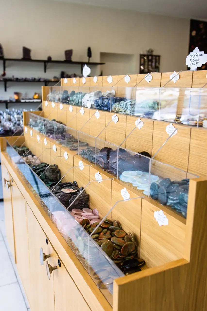 Wooden display case with glass front and clear plastic drawers containing various jewelry items.